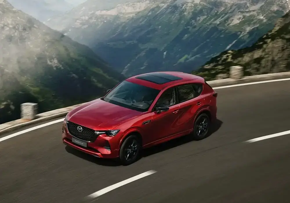 Mazda CX-60 rojo brillante conduce por una carretera sinuosa